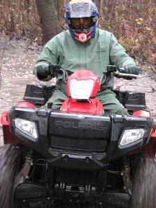 ATV guide and test rider Les Pinz pushes the Polaris hard through a mud pool.