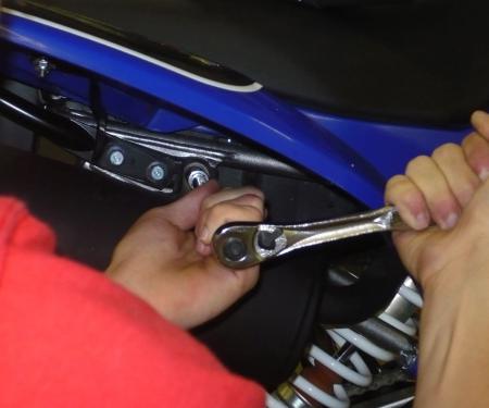 Loosen clamp between muffler and header. Remove upper and lower muffler bolts.